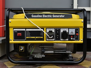 Portable generator that is yellow and black and says Gasoline Electric Generator on the side of it.
