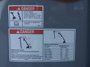 Warning stickers found on Aerial Lifts that warn against using near overhead power lines.