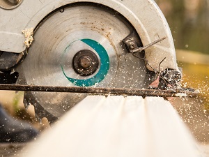 Close-up view of a circular saw cutting a piece of wood.