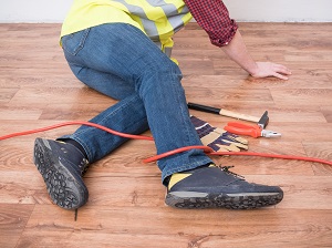 Construction worker has tripped on an extension cord.