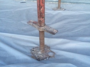 Scaffolding legs on base plates.