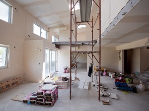 Supported scaffold being used incorrectly in an indoor construction area.
