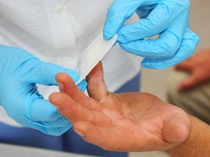 Person Wearing Gloves Putting a Band-Aid on Another Person