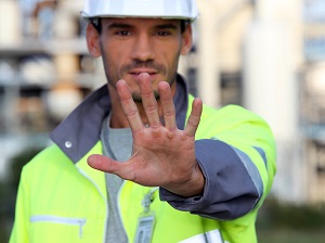 Construction worker putting his hand out to signal "stop".