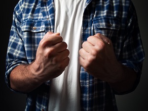 Man with two raised fists as if he is ready to fight.