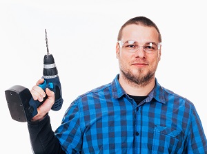 Man Holding Cordless Drill Wearing Safety Glasses
