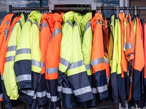 Clothes Rack Holding Orange and Yellow Assorted HVSA Jackets and Shirts