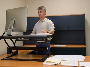 Man Doing Computer Work at a Standing Desk in Office