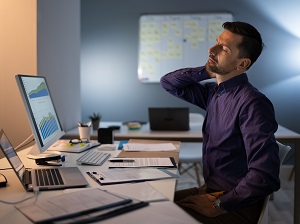 Man Sitting at Office Desk with Obvious Neck Discomfort
