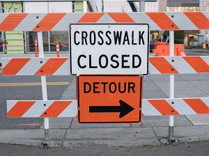Barrier with Crosswalk Closed and Detour Signs on it