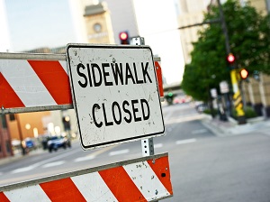 Sidewalk Closed Sign on Warning Barrier