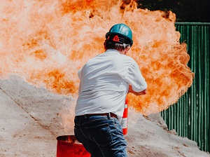 Worker Putting Out Fire with Fire Extinguisher