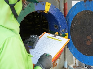 Supervisor reviewing confined space checklist on clipboard before entry