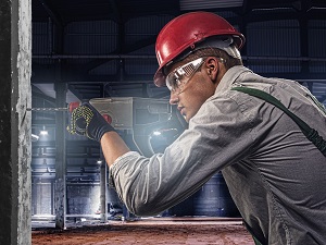 Construction Worker Wearing Safety Glasses While Using Drill