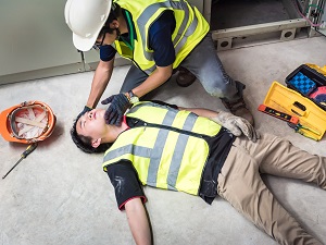 Worker Assessing Injured Worker Who is Unconscious