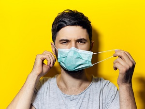 Man Removing Surgical Face Mask by Loops