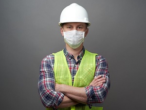 Working Wearing Hardhat, Safety Vest and Face Mask