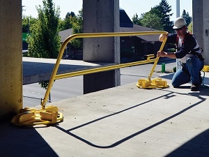 Construction Worker Installing Fall Protection Guardrails