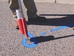 Locator putting blue locate paint on the ground.
