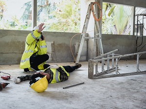 A worker fell off a step ladder and another worker is calling for help.