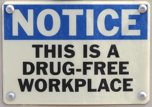 Sign bolted to the wall that reads, "Notice, this is a drug-free workplace."