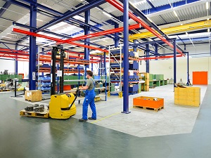 Warehouse worker pushing a pallet jack.