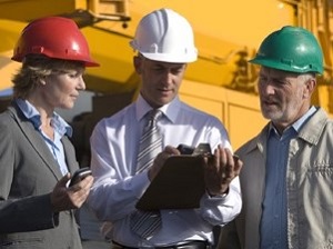 OSHA Inspector with Two Supervisors at Job Site, Wearing Hardhats