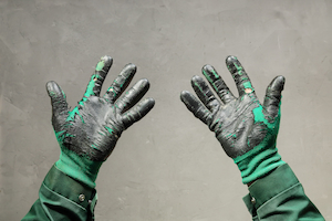 Worn coated work gloves showing damage and deterioration on palms and fingers.