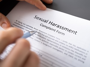 A person filling out a Sexual Harassment Complaint Form.