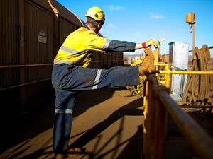 A construction worker stretching on the job.