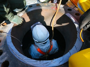 A worker getting into a confined space.