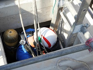 A worker getting into a confined space.