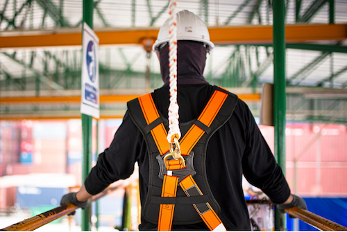 Worker tied off with a fall protection harness while working from an elevated platform.