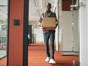 Man walking through office building carrying a box correctly.