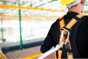 Worker tied off with a fall protection harness while working from an elevated platform.