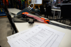 Fall protection harness and inspection checklist on a table before use.