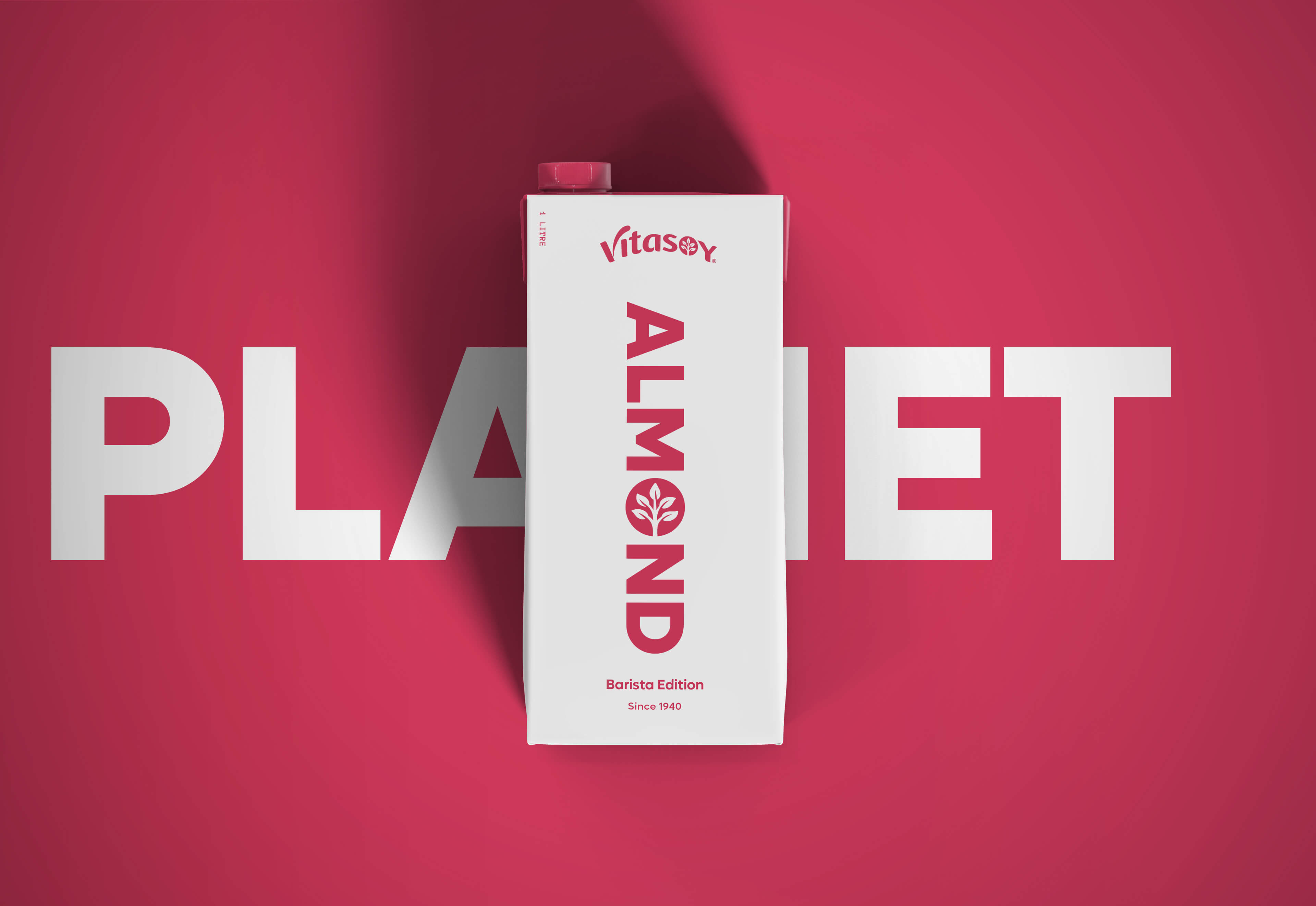 Vitasoy Barista Edition Almond Milk carton centred on a bold magenta background with large white text reading ‘PLANET’ behind. The minimalist white carton features vertical almond-coloured typography and the Vitasoy logo.
