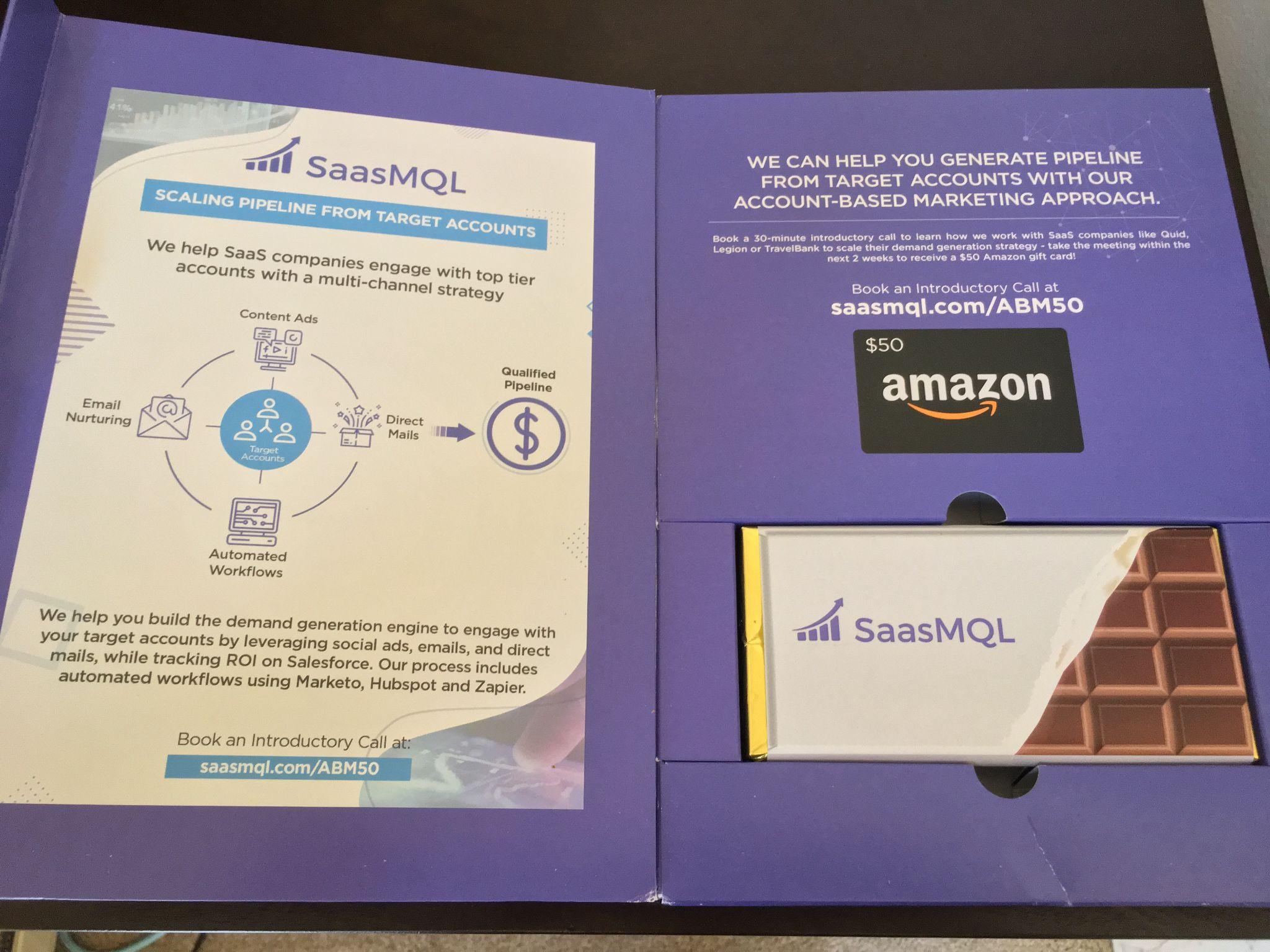 SaaSMQL direct mail package with campaign messaging, an Amazon gift card, and branded chocolate