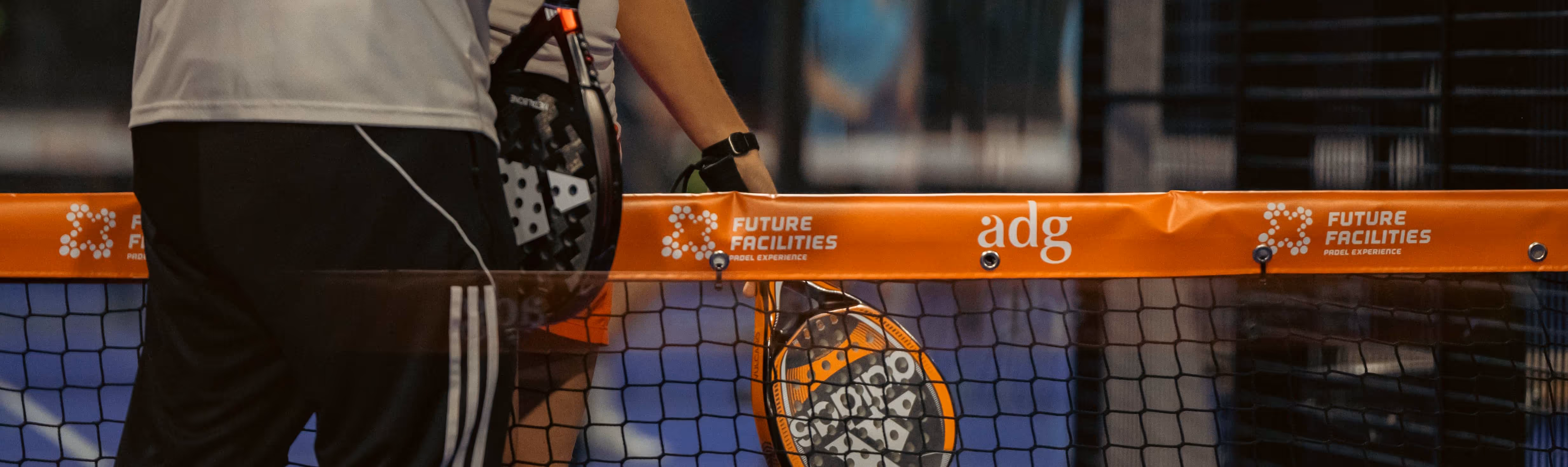 Een padelnet in oranje stijl met logo's ontworpen door de afdeling Vormgeving & Design van sportmarketingbureau FrontRow