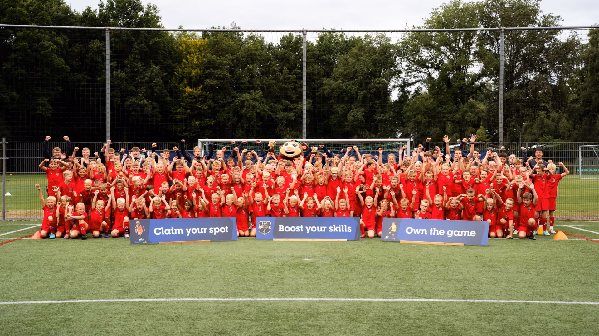 Een groep jongens in voetbaltenue poseren voor een groepsfoto tijdens een B2C sportevenement