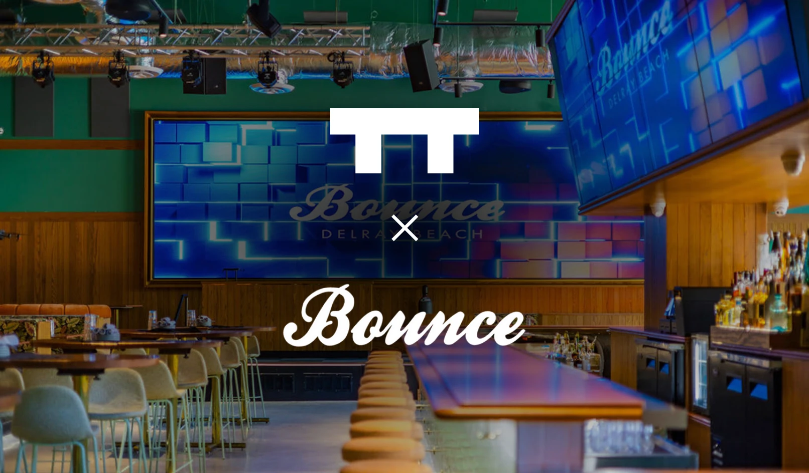 Interior view of a modern bar with stools, tables, and a large neon Bounce Delray Beach sign.
