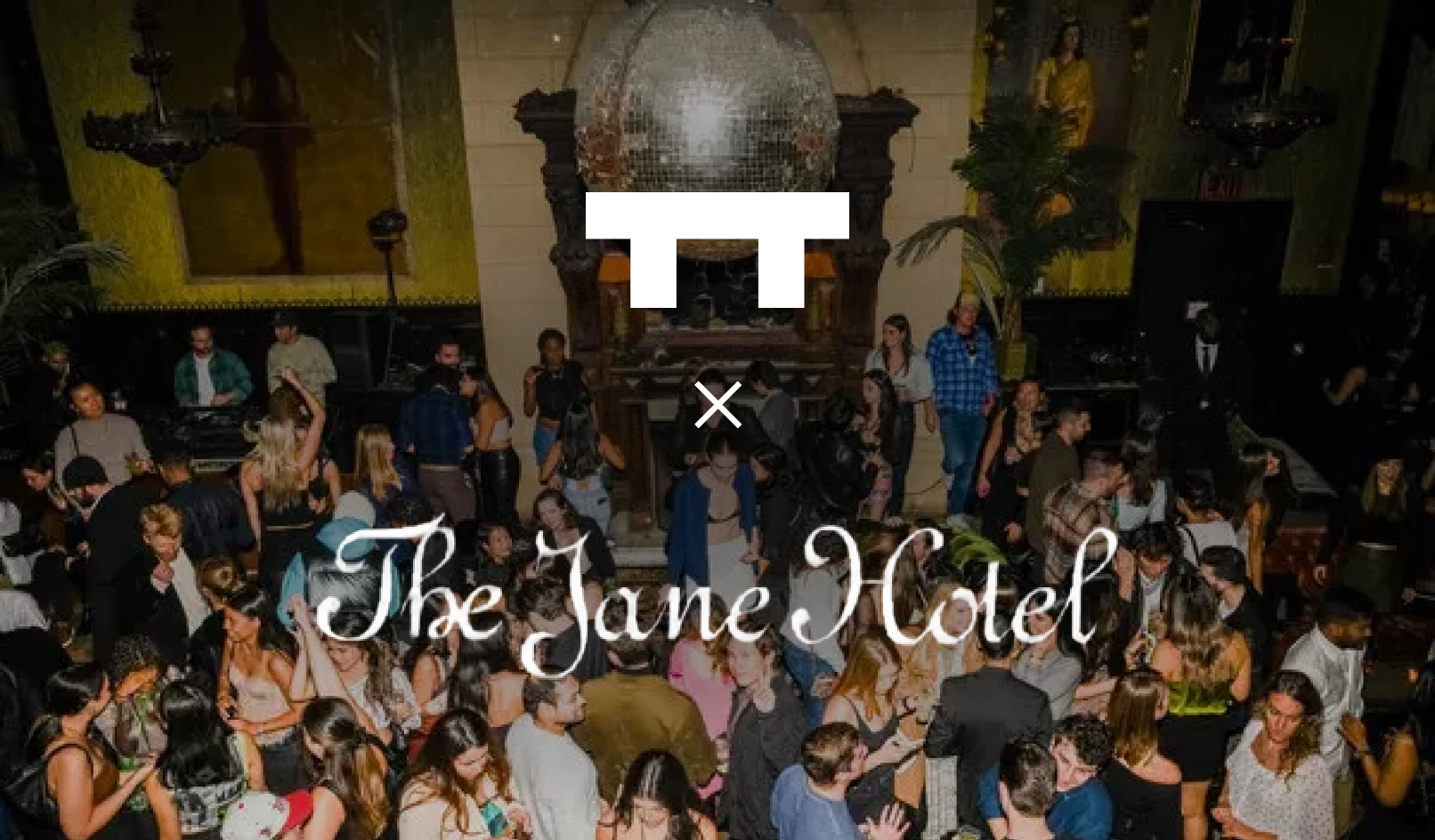 Crowded nightlife scene at a hotel ballroom with people socializing under a large disco ball.
