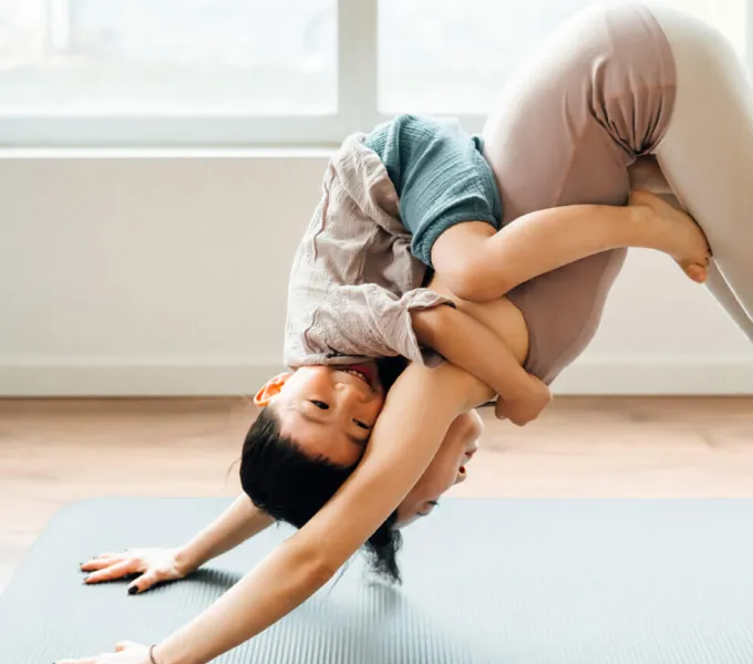 Woman doing yoga with child.