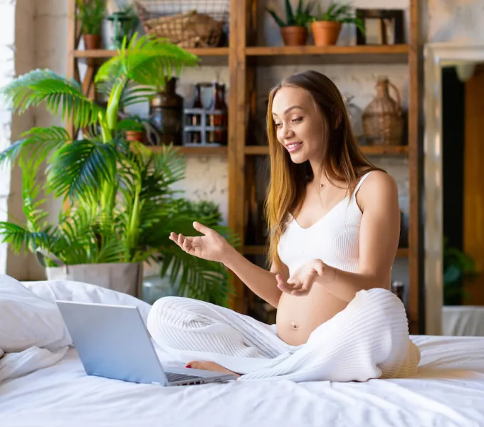 A pregnant woman having a virtual visit with a pelvic floor physical therapist.