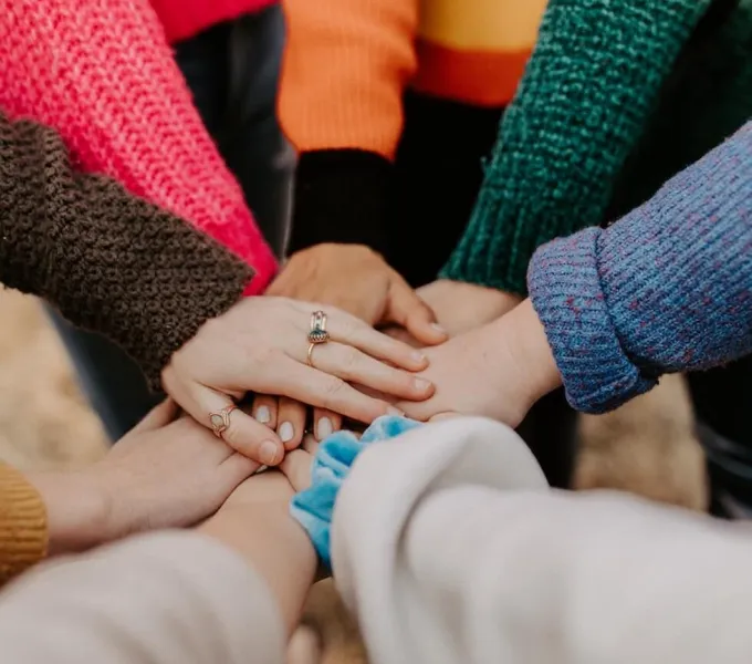 Women putting their hands together for amazing researchers in women's health.