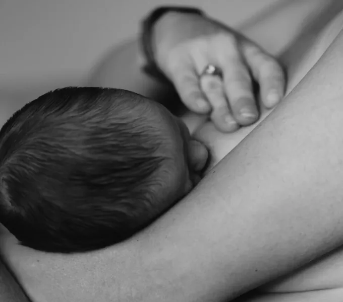 A woman holding her postpartum breasts.