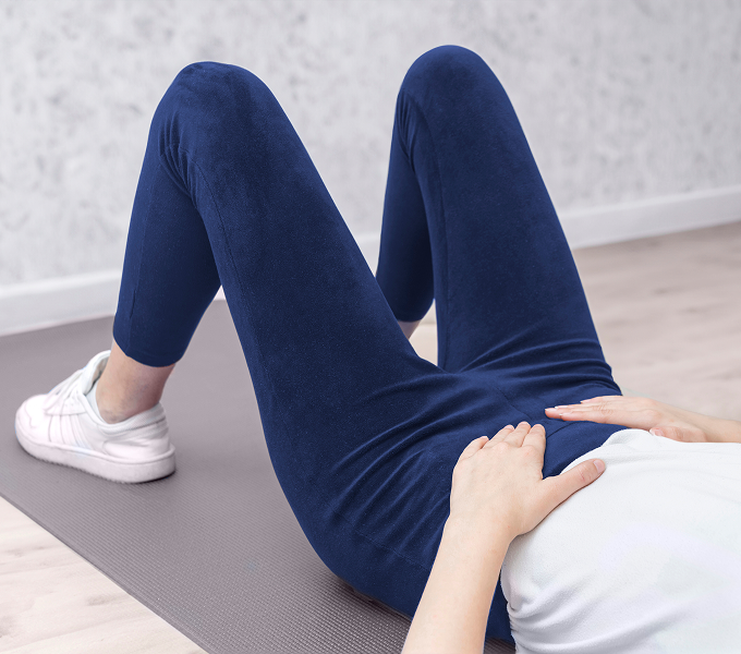 Woman with PCOS doing physical therapy exercises to help manage PCOS pain naturally.