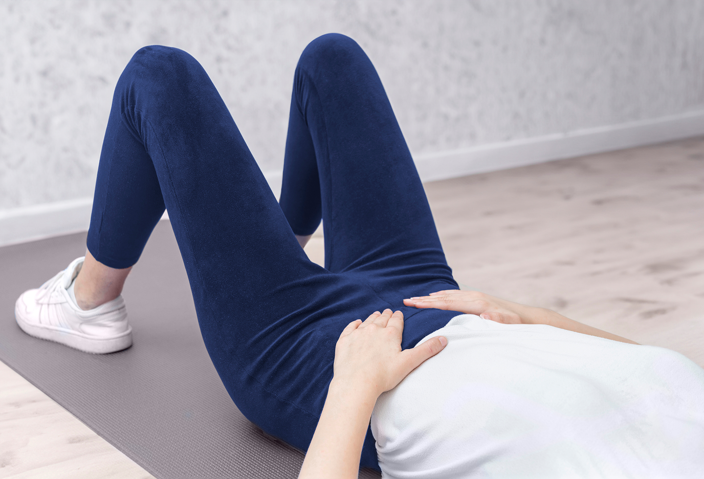 Woman with PCOS doing physical therapy exercises to help manage PCOS pain naturally.