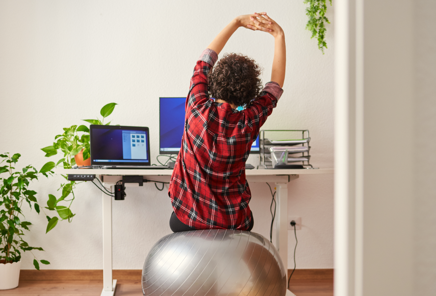 Woman sitting at her ergonomic workstation and doing exercises to support her physical and pelvic health.