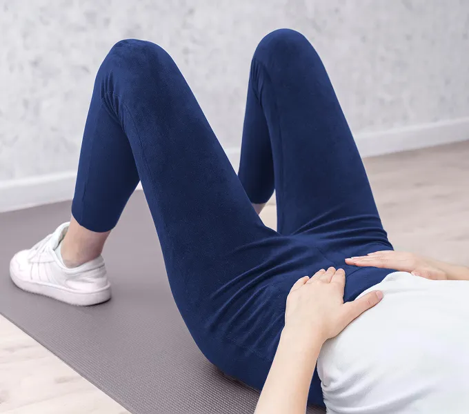 Woman with PCOS doing physical therapy exercises to help manage PCOS pain naturally.